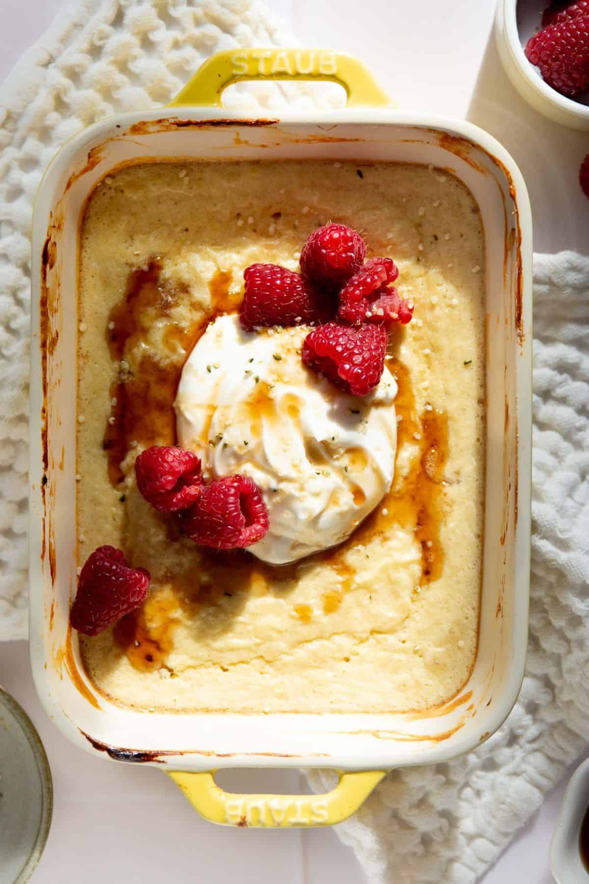 High protein vanilla pancake bowl topped with Greek yogurt, raspberries, and maple syrup.