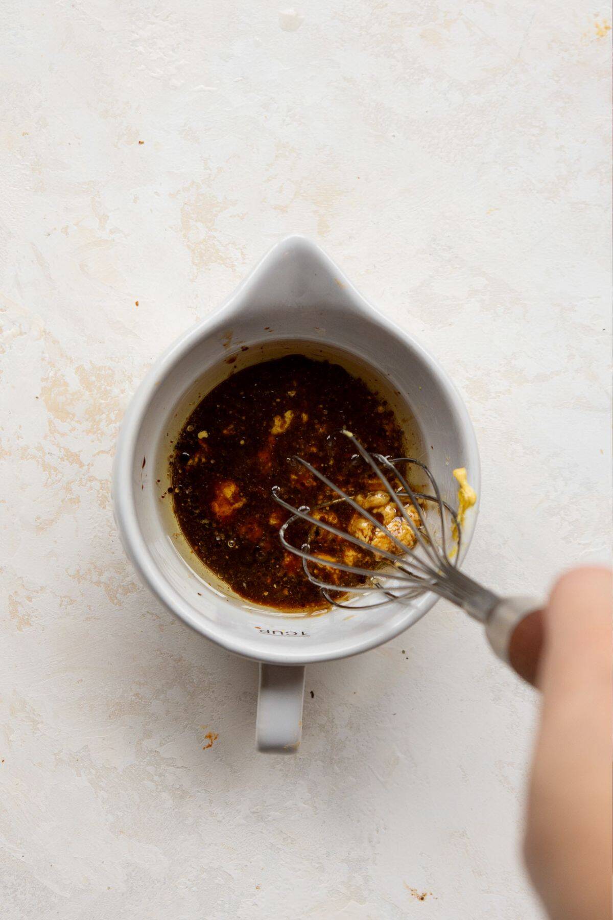 Whisking together the balsamic dijon vinaigrette in a small bowl
