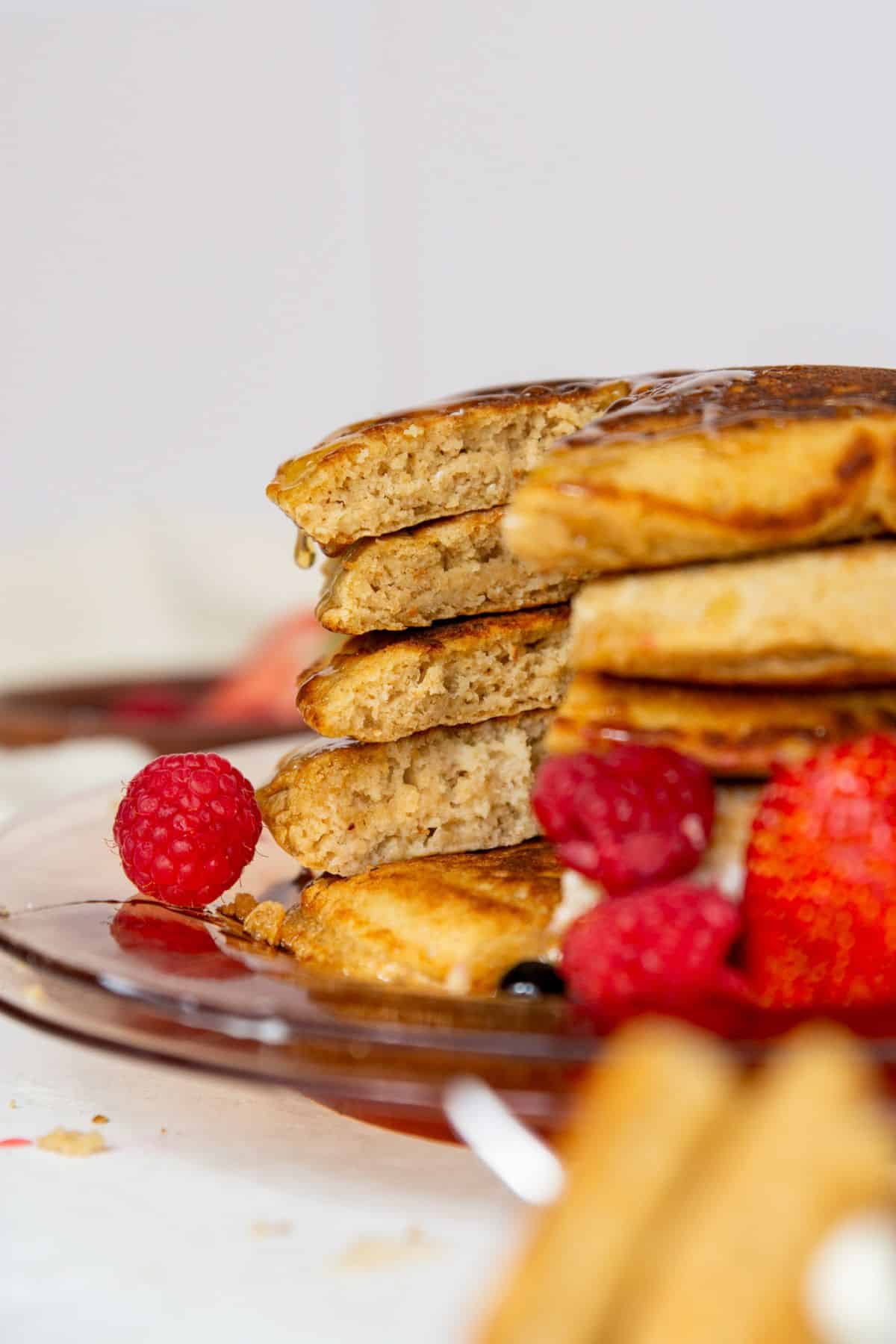Buttermilk oat flour pancakes with crisp buttery edges cut open to show super tender, soft, and fluffy centers.