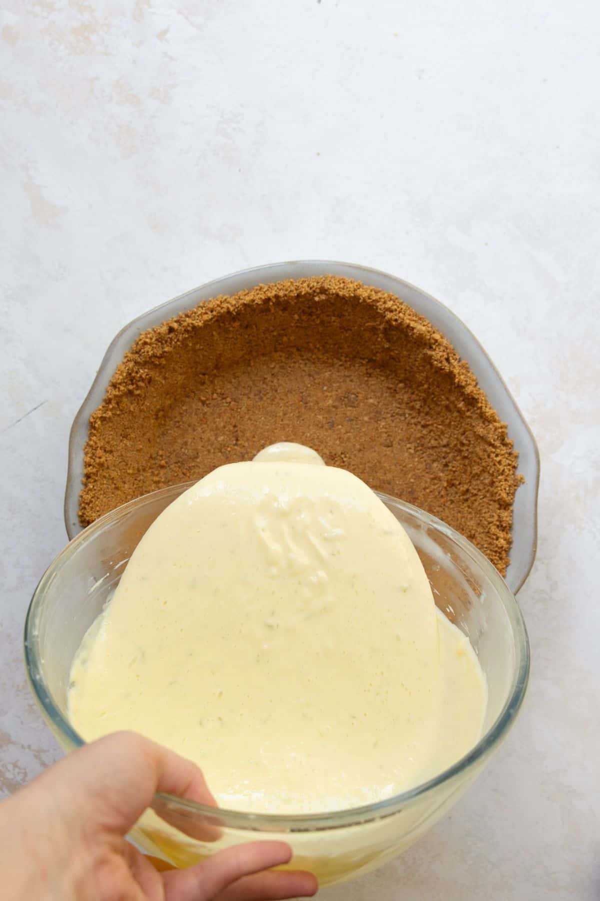 Pouring key lime filling into gluten-free graham cracker crust.