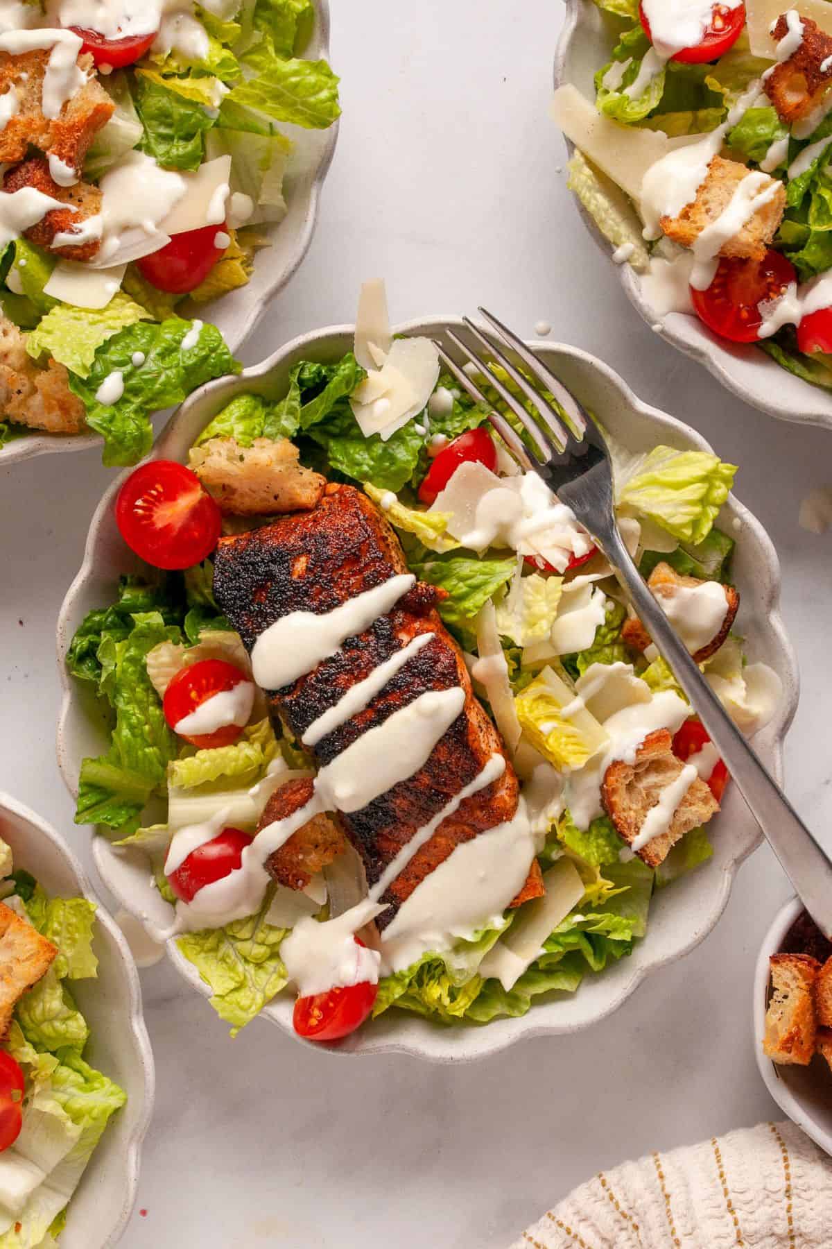 Crispy blackened salmon Caesar salad with sourdough croutons and drizzled healthy caesar dressing.