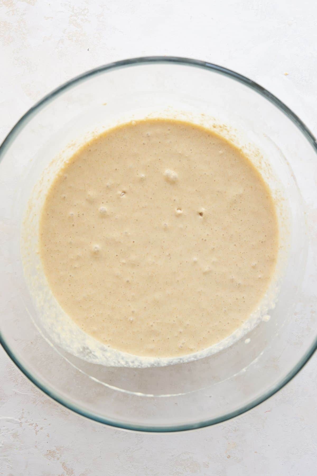 Oat flour pancake batter resting in a glass bowl.