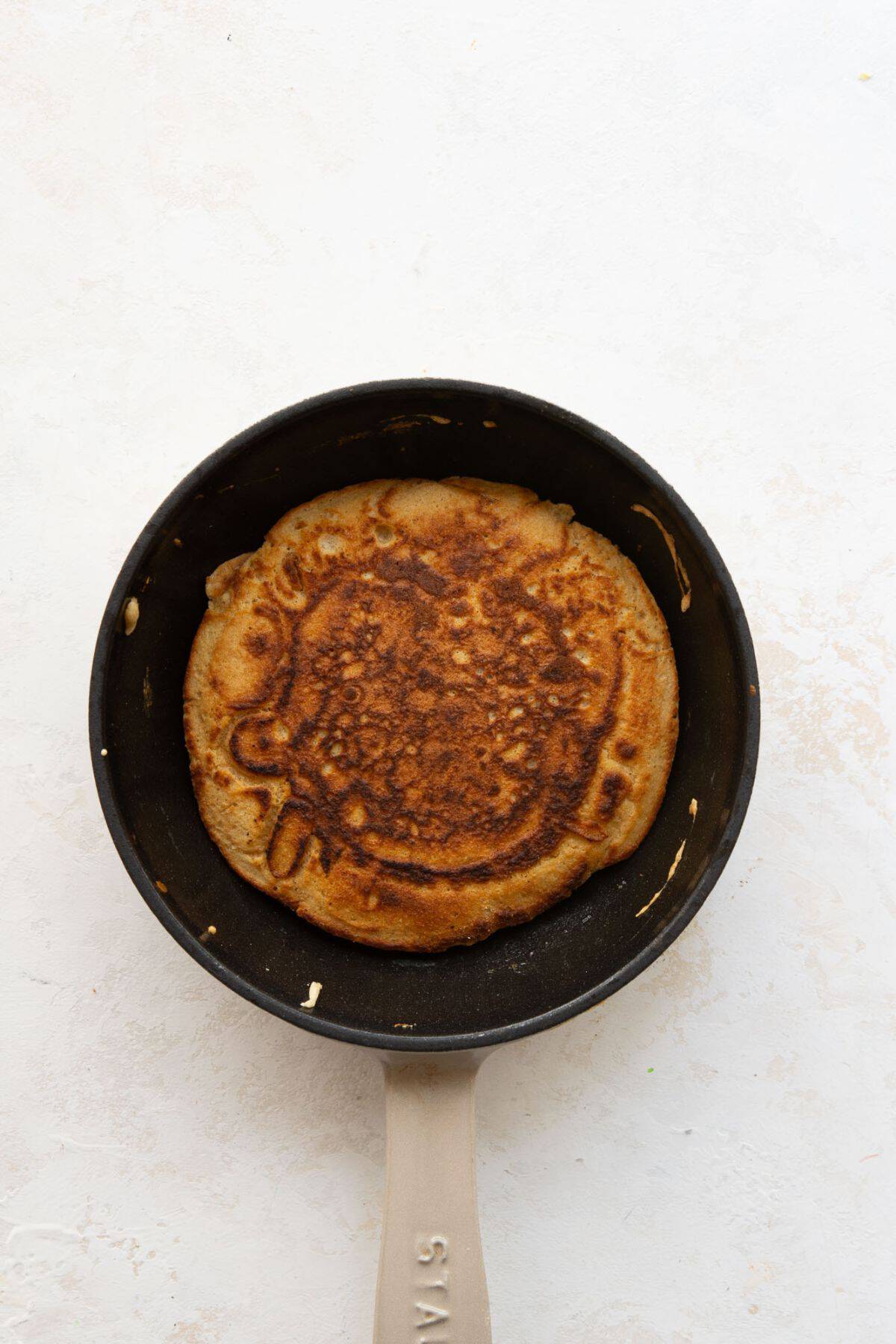 Golden brown, oat flour pancake in a skillet.