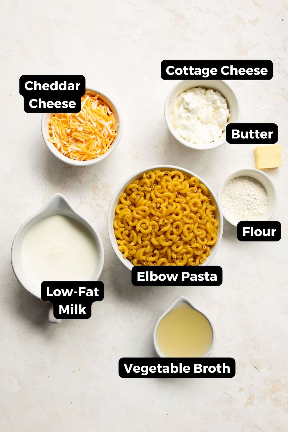 all ingredients in healthy mac and cheese, including: cottage cheese, cheddar cheese, low-fat milk, flour, vegetable broth, noodle, and butter.