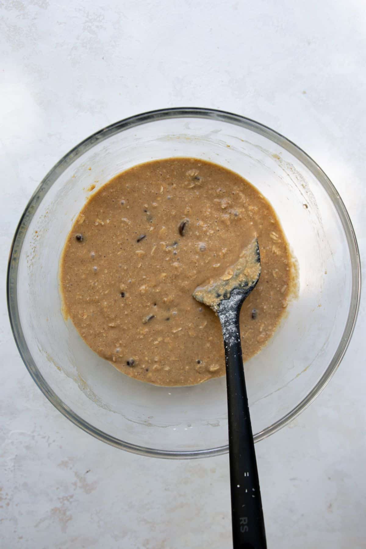 Smooth, fully mixed batter for healthy chocolate chip oatmeal bars in a glass bowl.