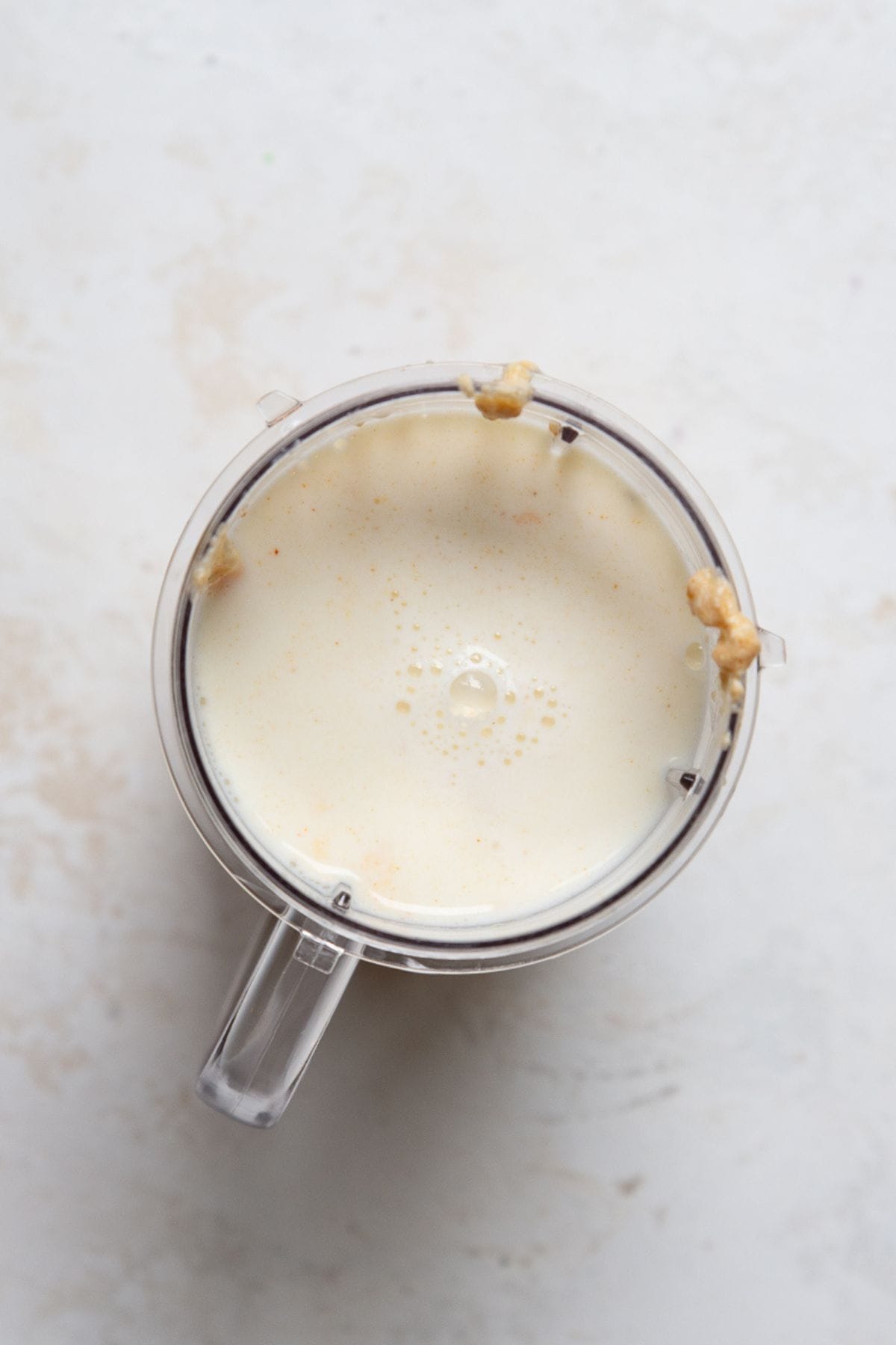 Cottage cheese queso poured into a blender with a splash of milk for the second blend.