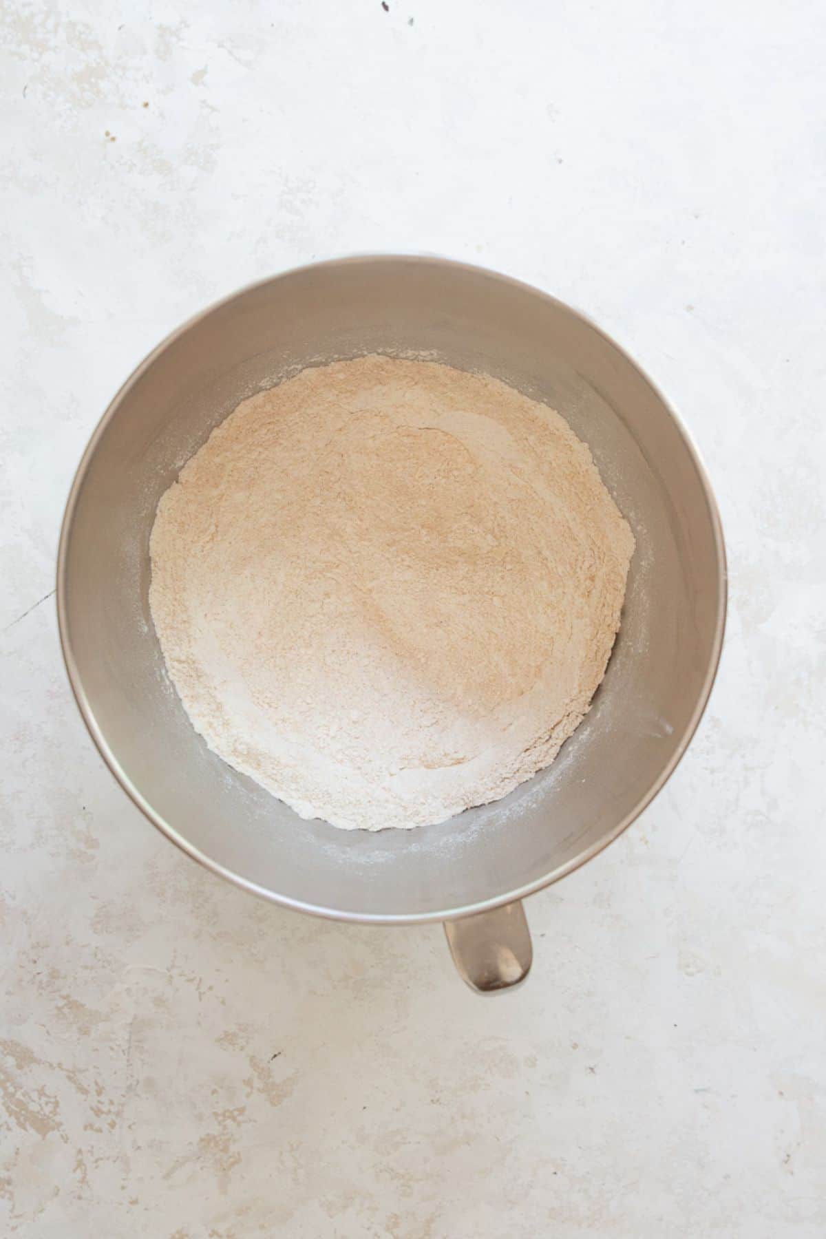 White whole wheat flour, all-purpose flour, and salt combined in a stand mixer bowl.