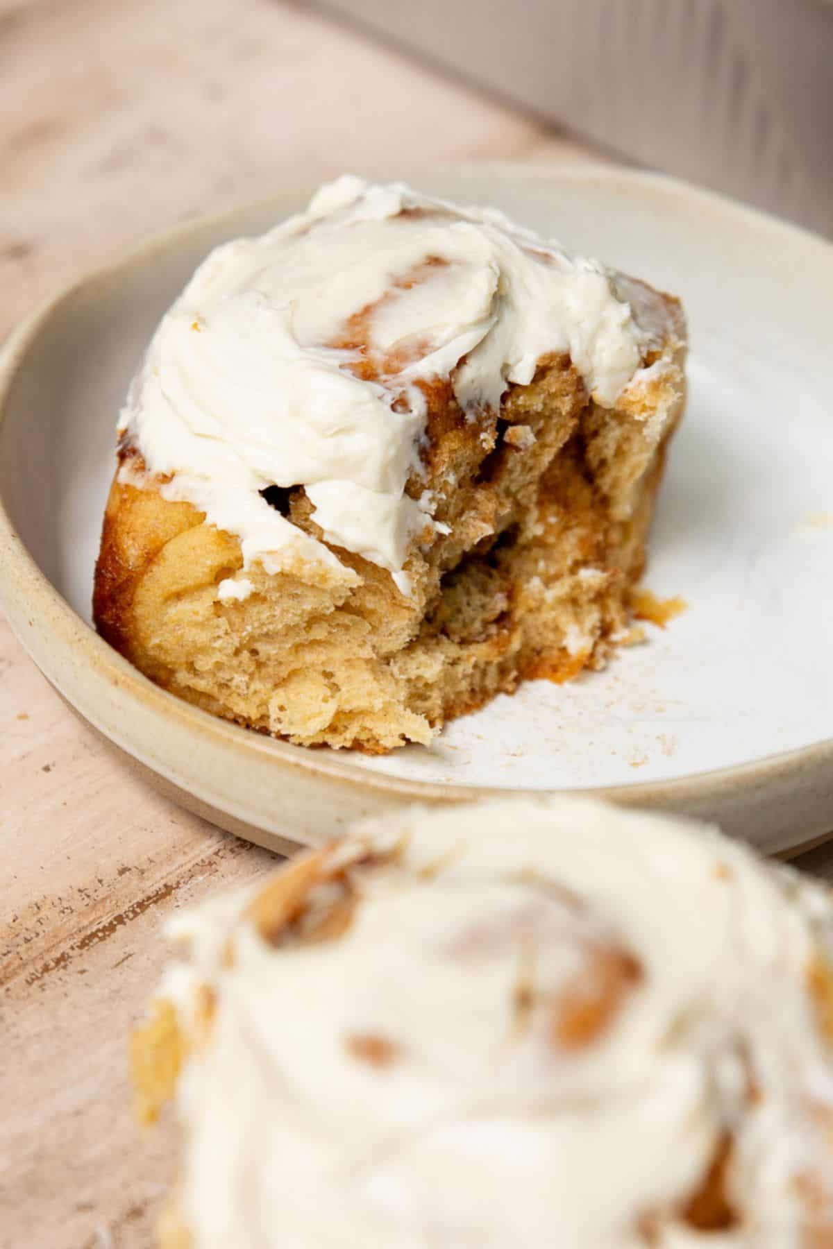 Healthy cinnamon roll on a plate the soft, fluffy interior layers and thick Greek yogurt icing on top.