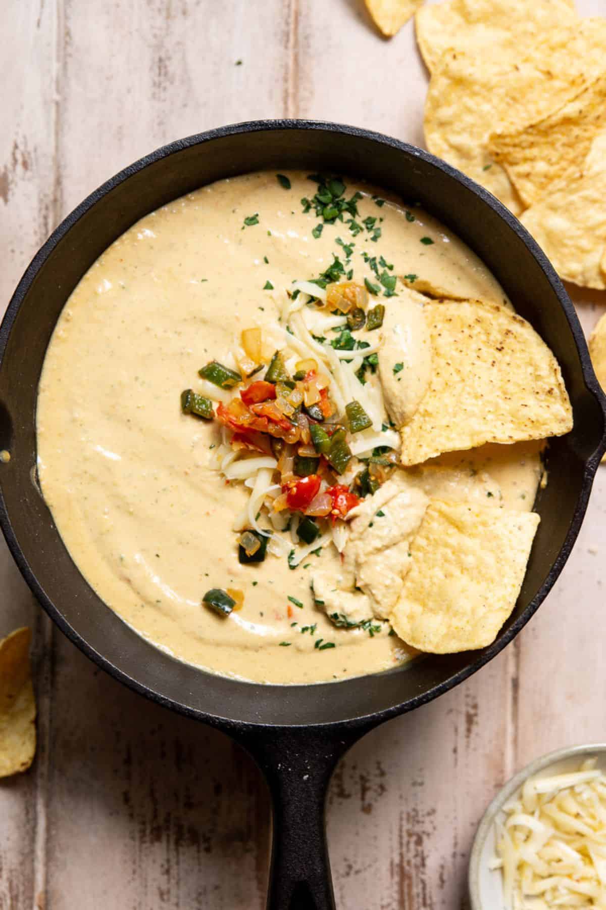 Creamy cottage cheese queso in a cast iron skillet served with tortilla chips.
