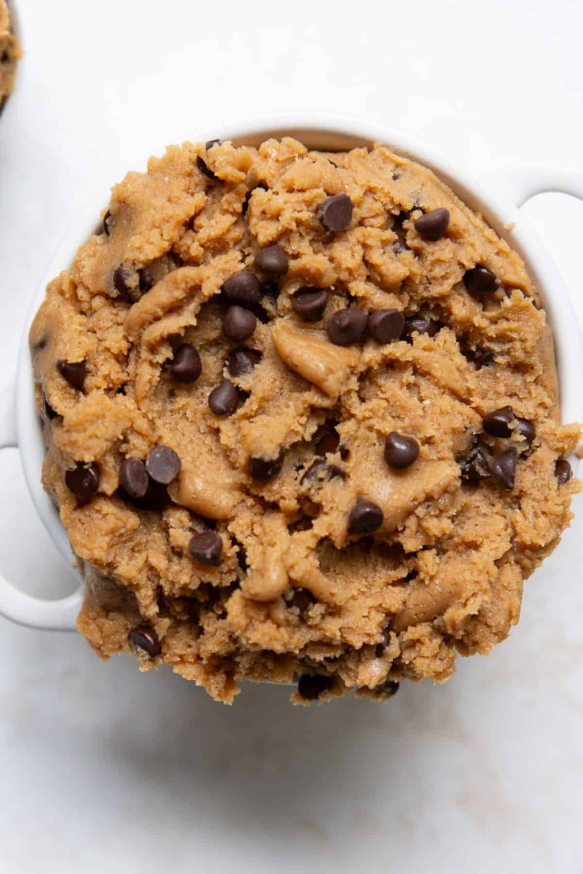 Bowl of high-protein edible cookie dough topped with mini chocolate chips.