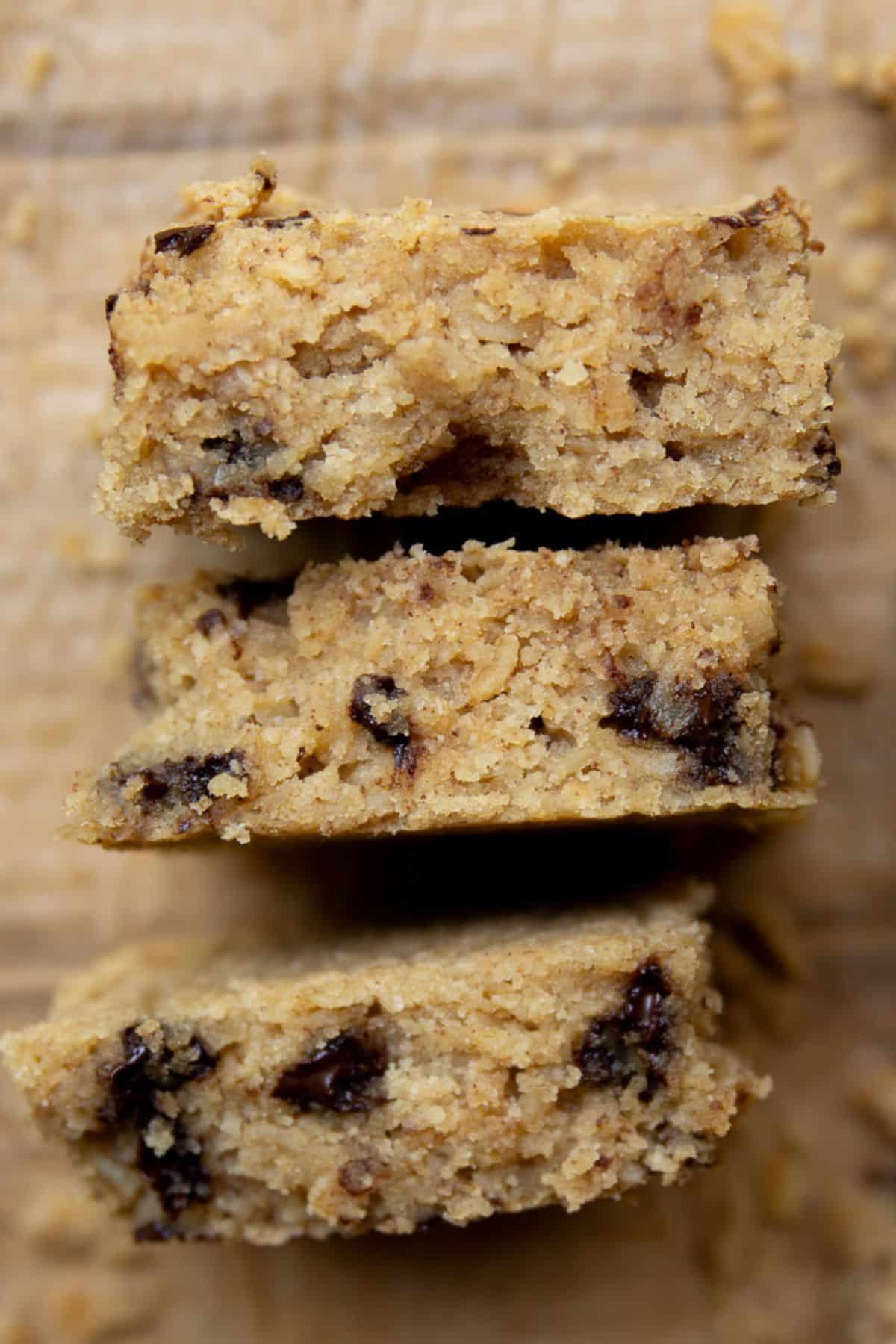 Close-up of the soft, moist inside texture of three stacked healthy chocolate chip oatmeal bars.