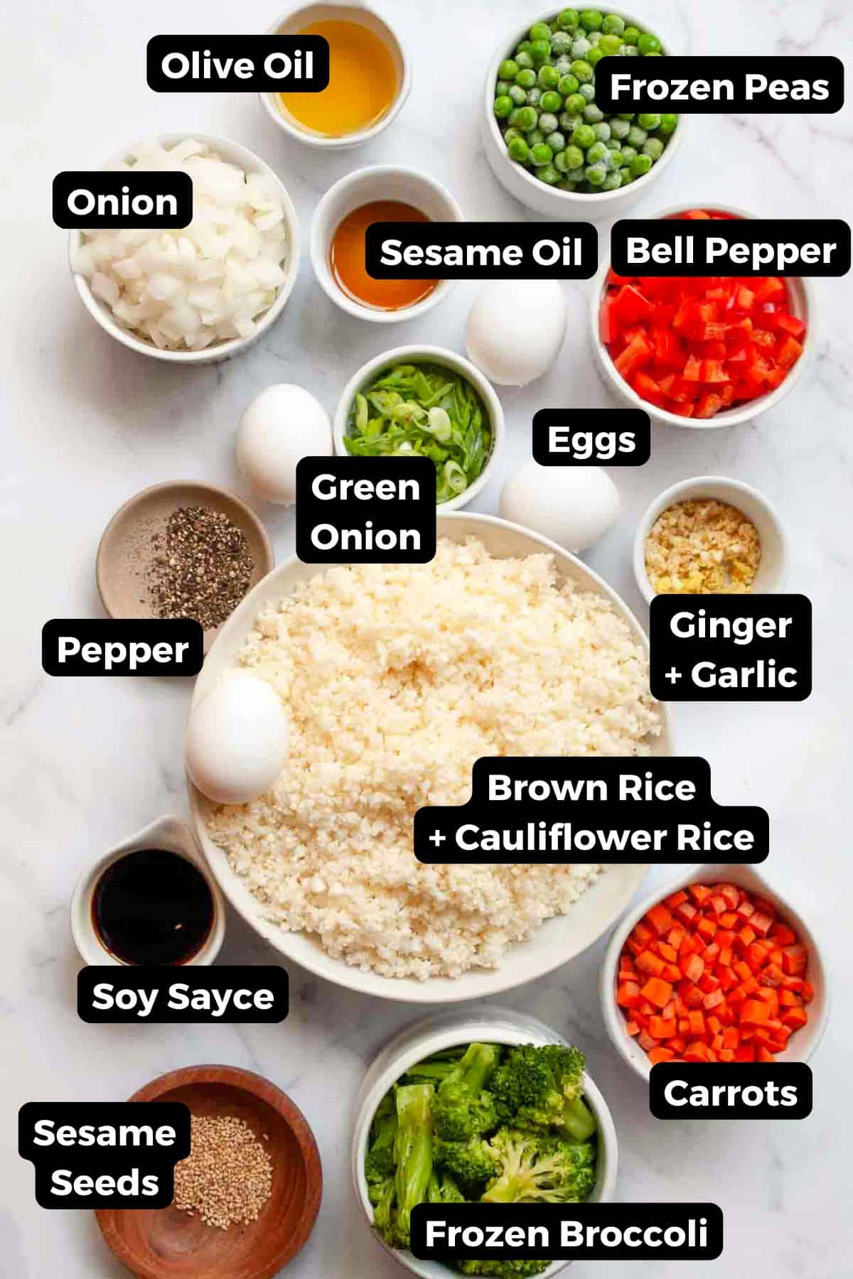 Ingredients for healthy fried rice including eggs, cauliflower rice, brown rice, sesame oil, frozen vegetables, ginger, garlic, and soy sauce.