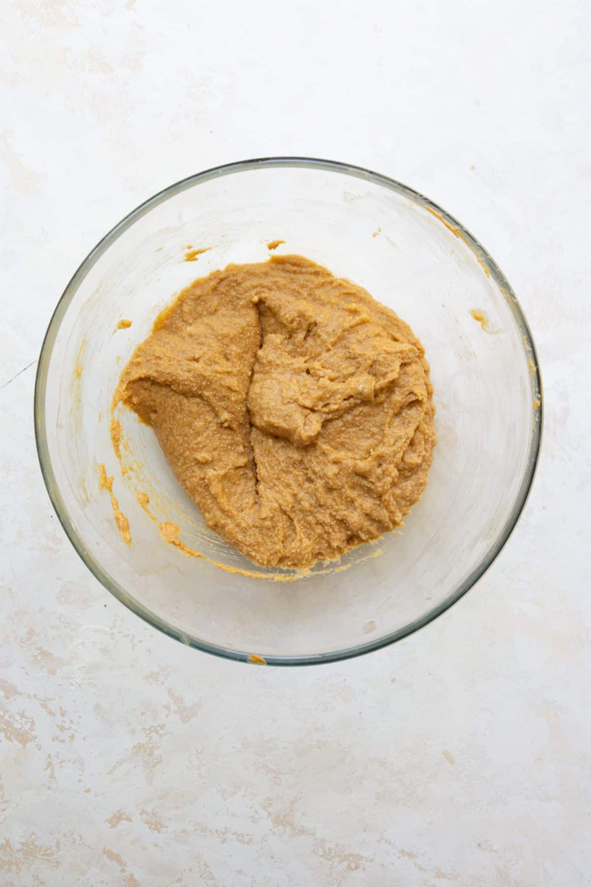Thick almond flour peanut butter banana muffin batter mixed in a bowl.