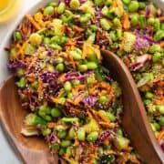 Easy Asian edamame crunch salad with puffed quinoa, cucumber, carrots, and cabbage, dressed in carrot ginger dressing.