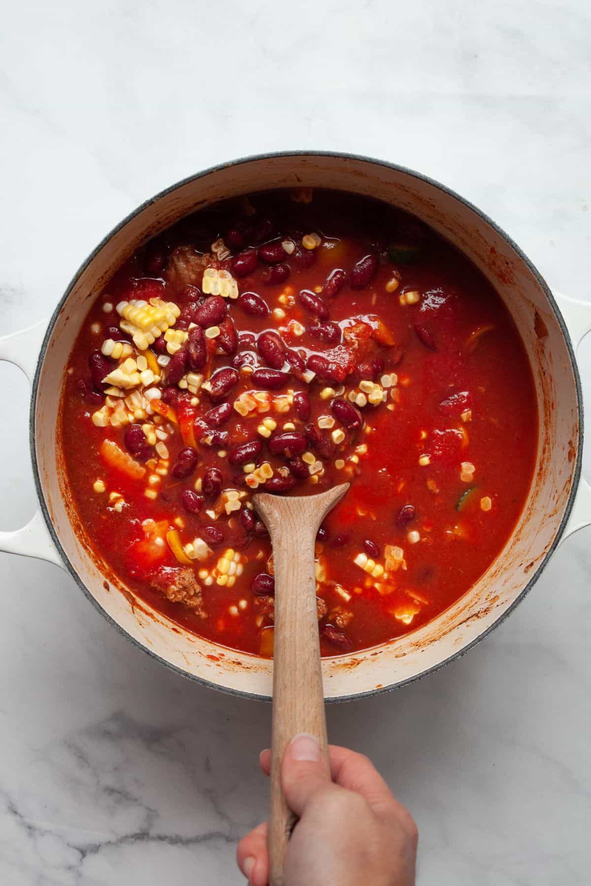 Kidney beans, corn, and crushed tomatoes stirred into ground turkey chili.