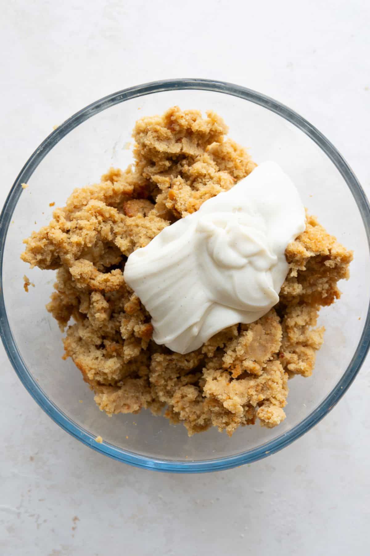 Adding Greek yogurt frosting to crumbled protein cake to form the cake pop filling.