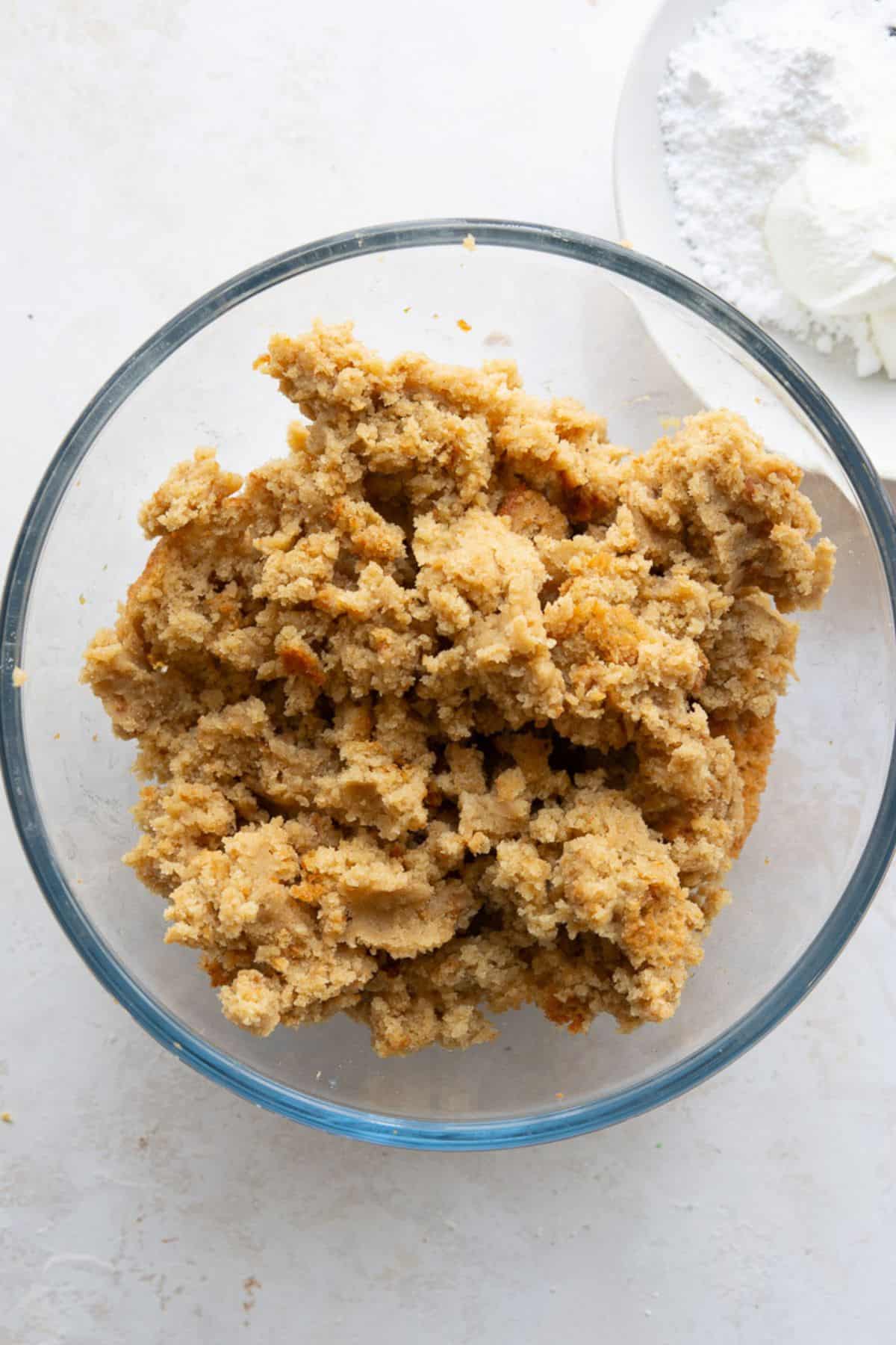 ooled protein cake crumbled into fine pieces in a glass bowl.