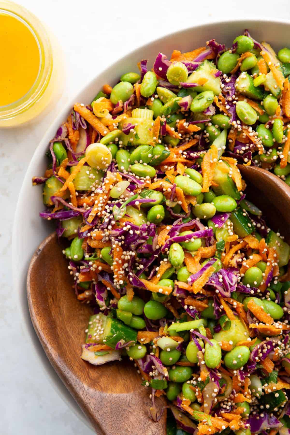 Nut-free Asian edamame crunch salad with edamame, shredded carrots, red cabbage, cucumber, and puffed quinoa.