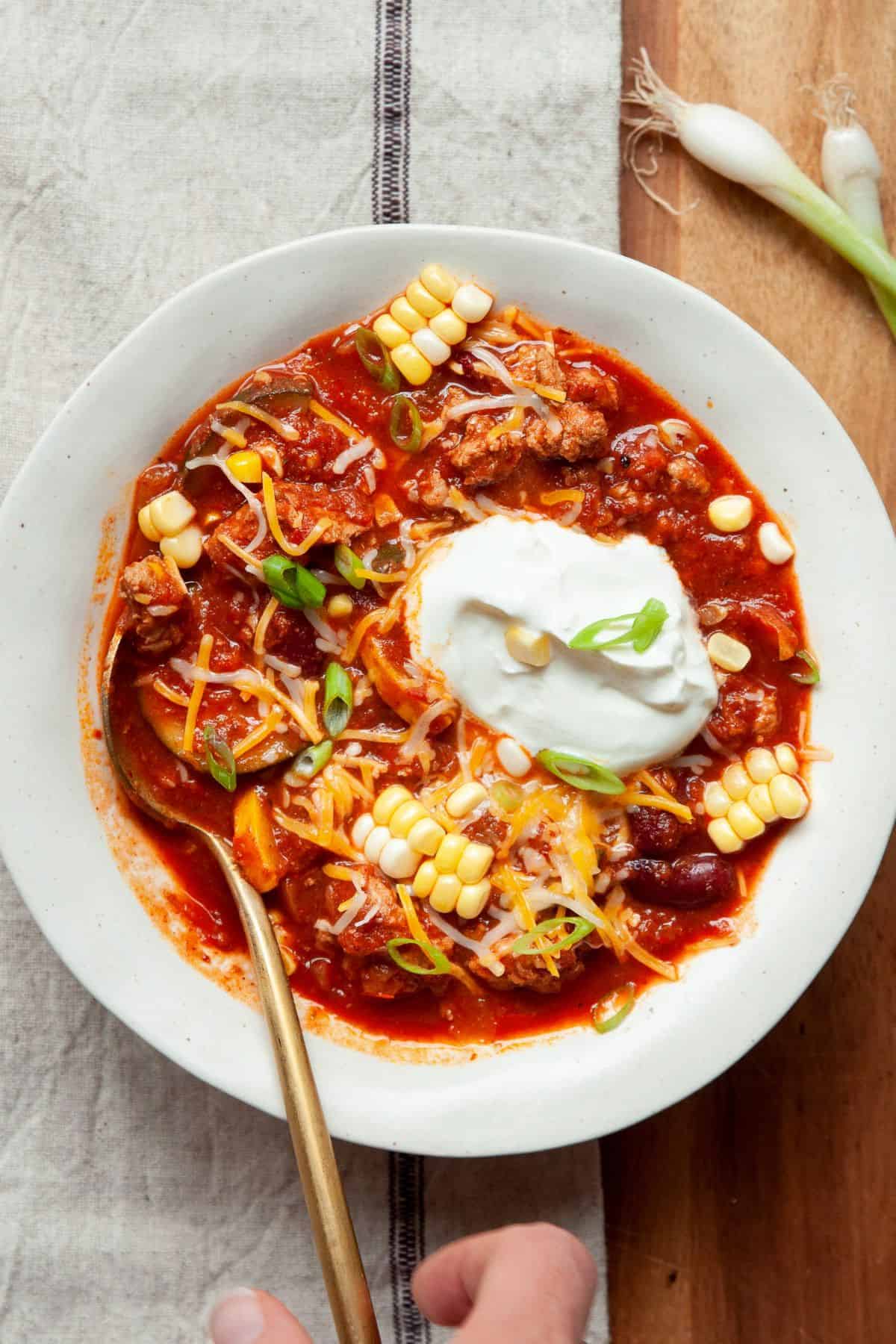 Bowl of high protein, healthy ground turkey chili with Greek yogurt.