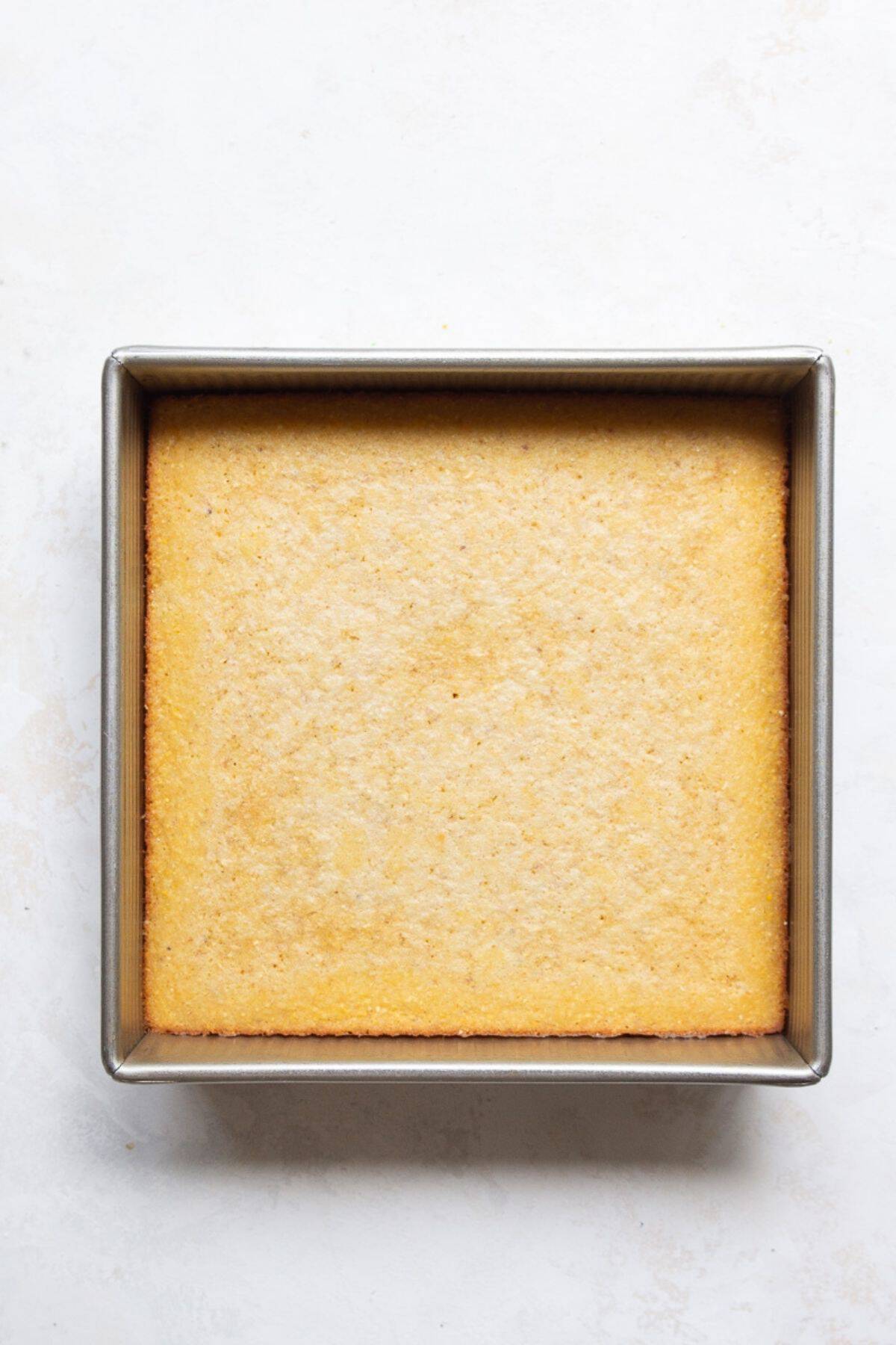Baked almond flour cornbread cooling in an 8x8 pan.