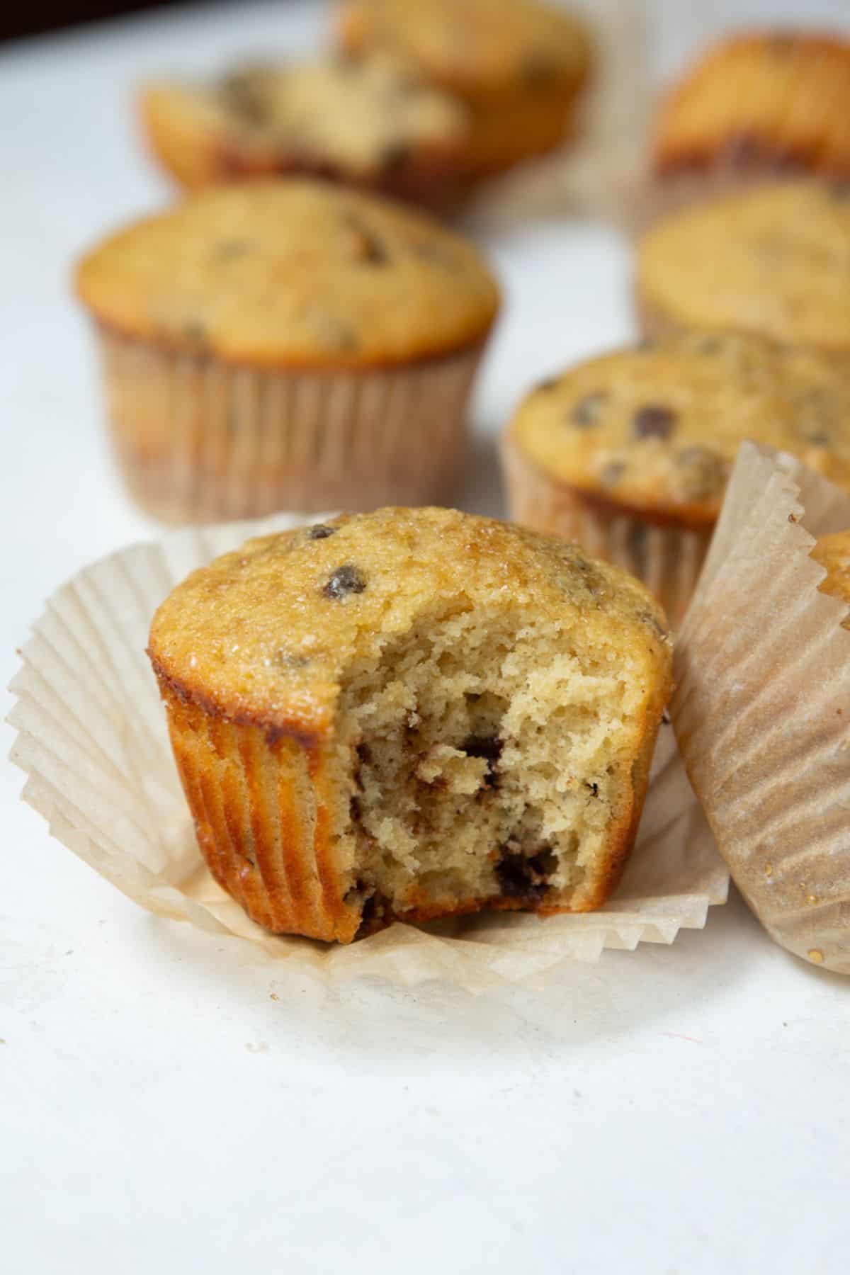 Chocolate chip protein muffin with a bite taken out showing a soft, tender crumb.