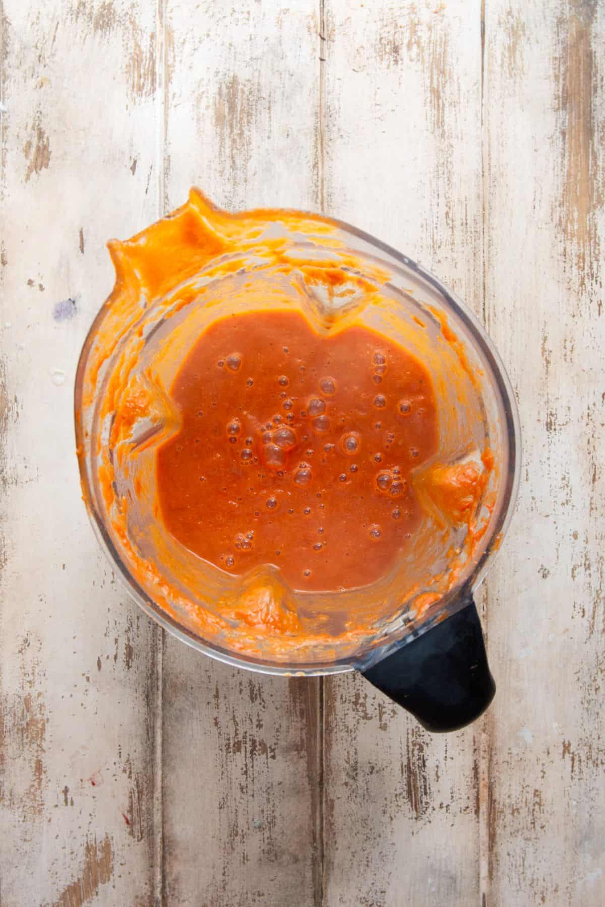 Tomato soup blended smooth in a countertop blender.