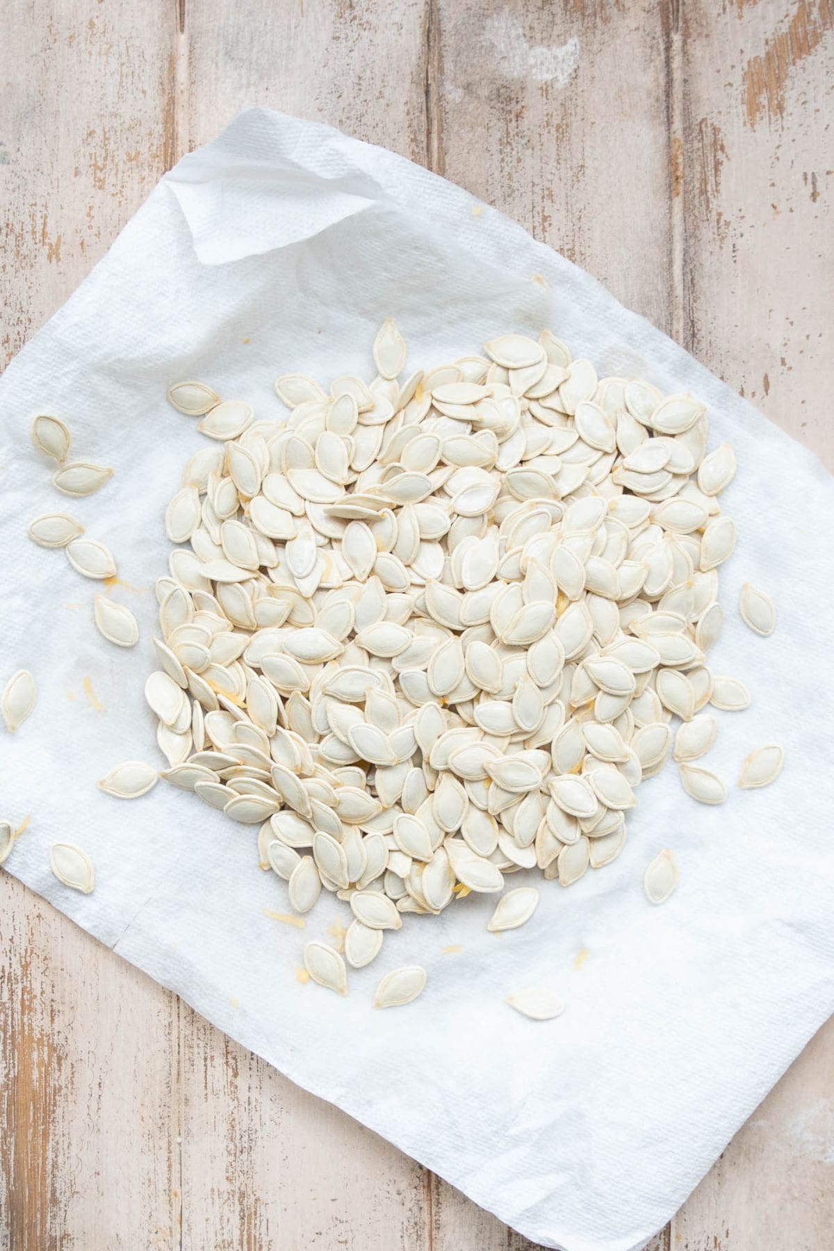 Pumpkin seeds patted dry on a clean towel before air frying.