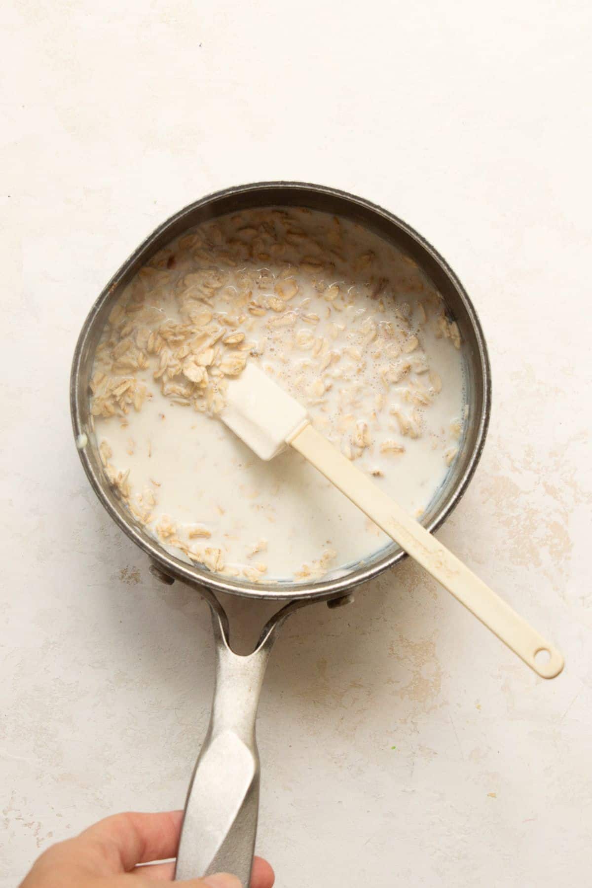 Rolled oats and milk in a small saucepan before cooking.