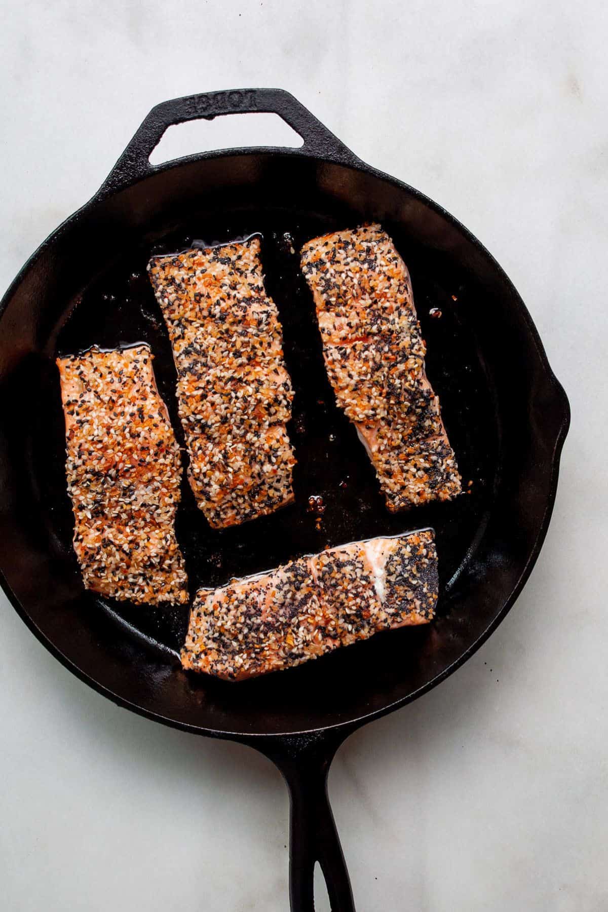 Everything bagel crusted salmon in a cast iron skillet after baking.