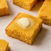 Square of healthy almond flour cornbread topped with a pat of butter.