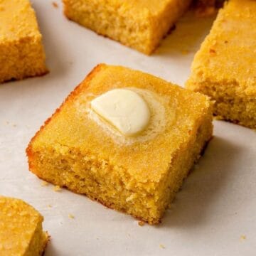 Square of healthy almond flour cornbread topped with a pat of butter.