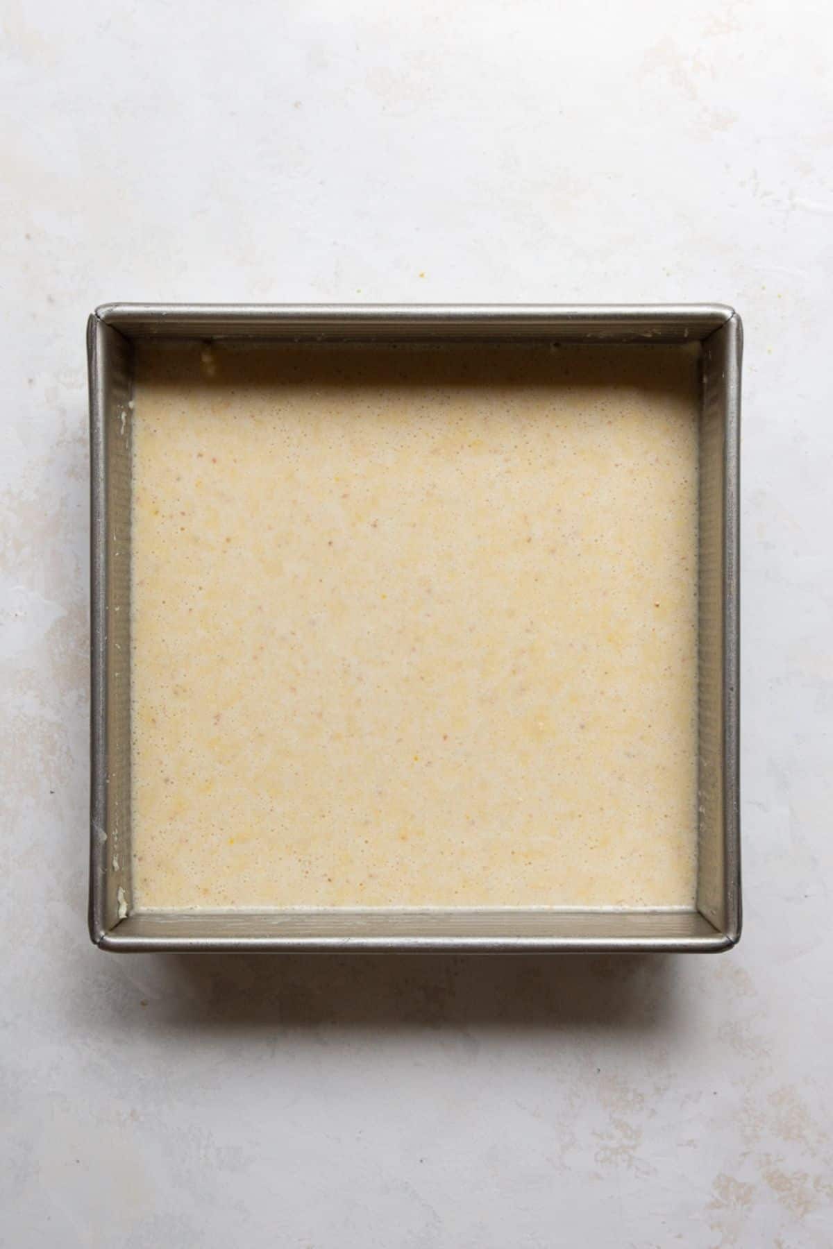 Cornbread batter poured into a greased 8x8 baking pan.