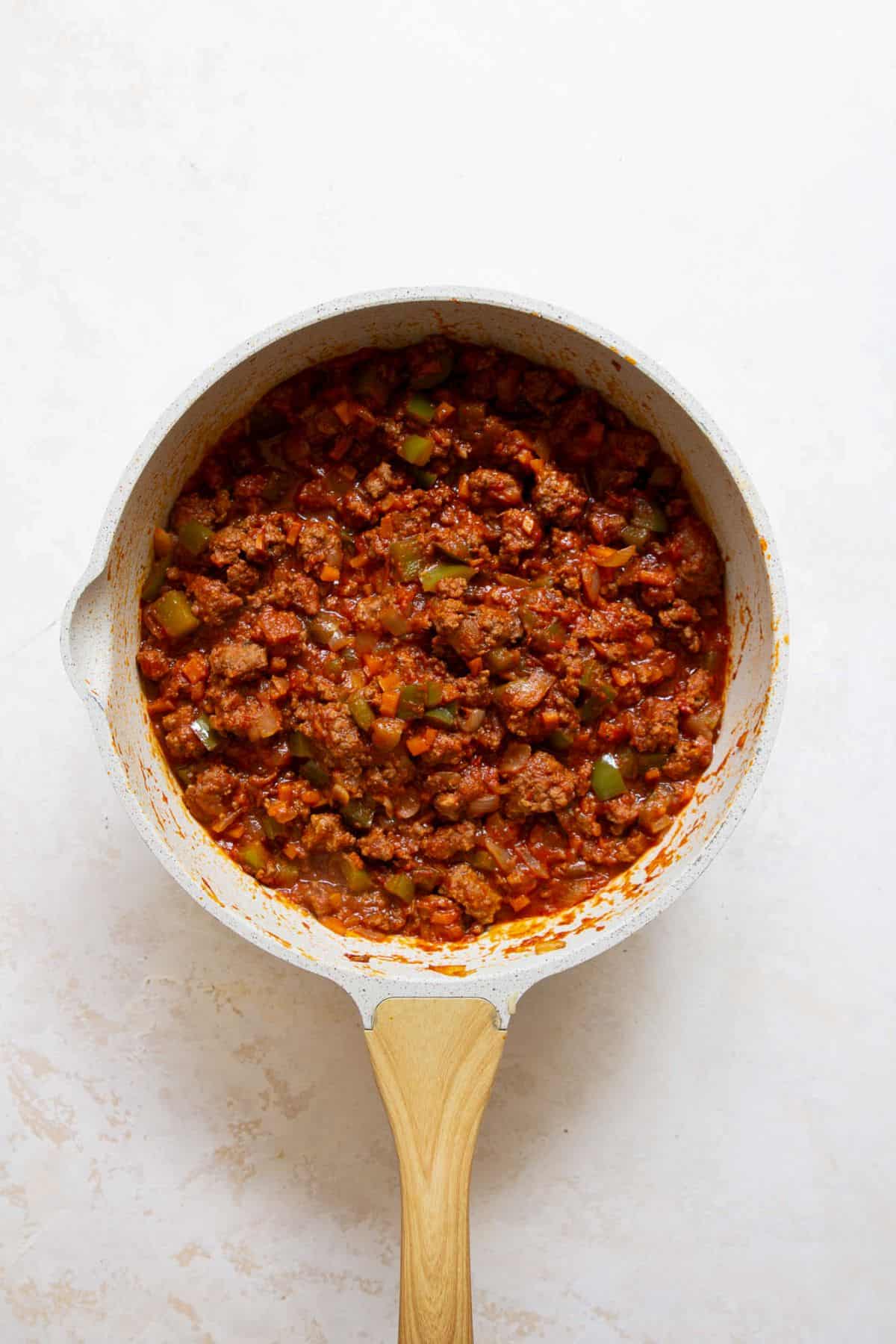 Thickened sloppy joe filling in a skillet after simmering.