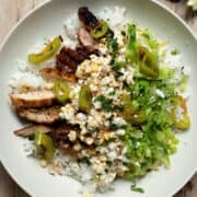 High protein Mexican street corn chicken rice bowls with crispy chicken, yogurt dressing, and shredded romaine.