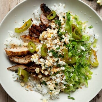 High protein Mexican street corn chicken rice bowls with crispy chicken, yogurt dressing, and shredded romaine.