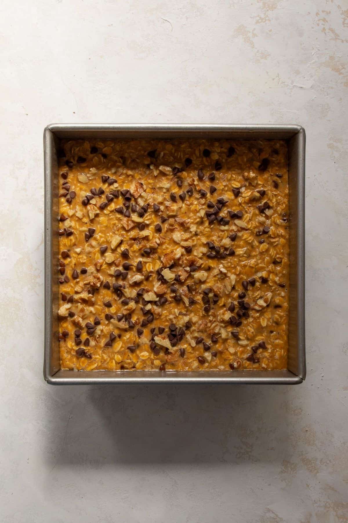 Baked pumpkin oatmeal in a square pan with a golden set top.