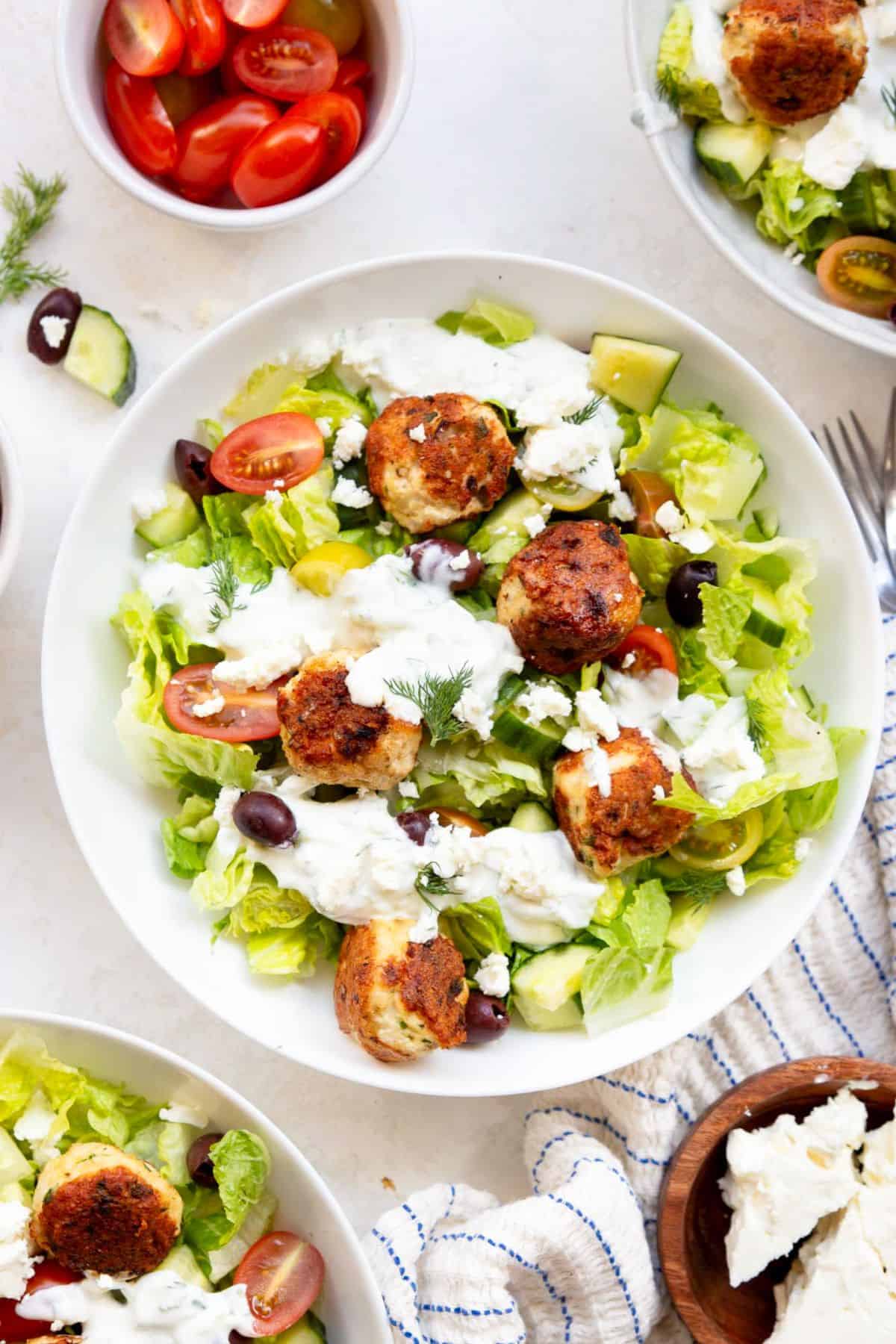 Greek chicken meatballs served over romaine with cherry tomatoes, cucumber, kalamata olives, and feta, drizzled with tzatziki.