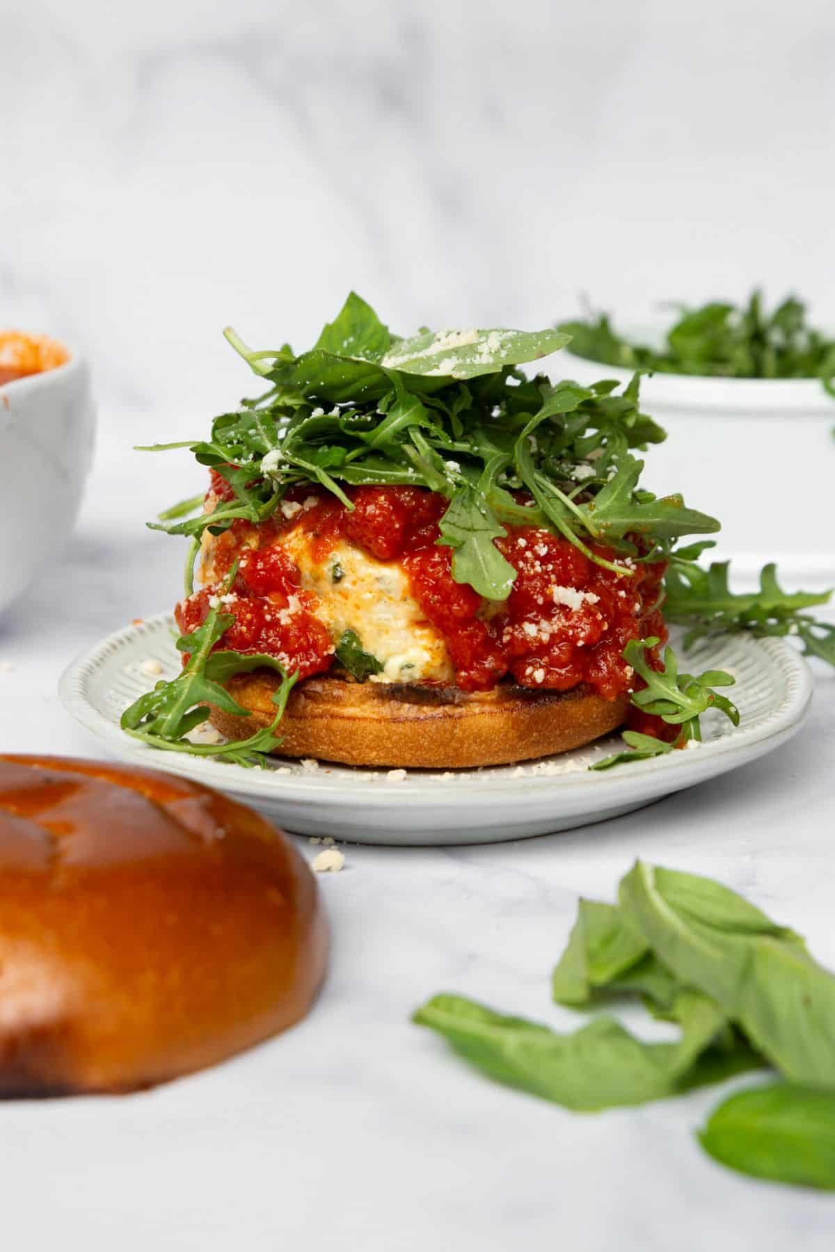 Stuffed chicken parmesan burger topped with marinara and arugula.