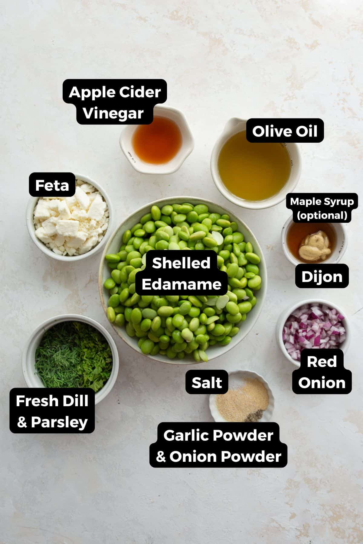 Ingredients for edamame salad with feta and dill, including shelled edamame, feta, fresh dill, parsley, red onion, olive oil, and apple cider vinegar.