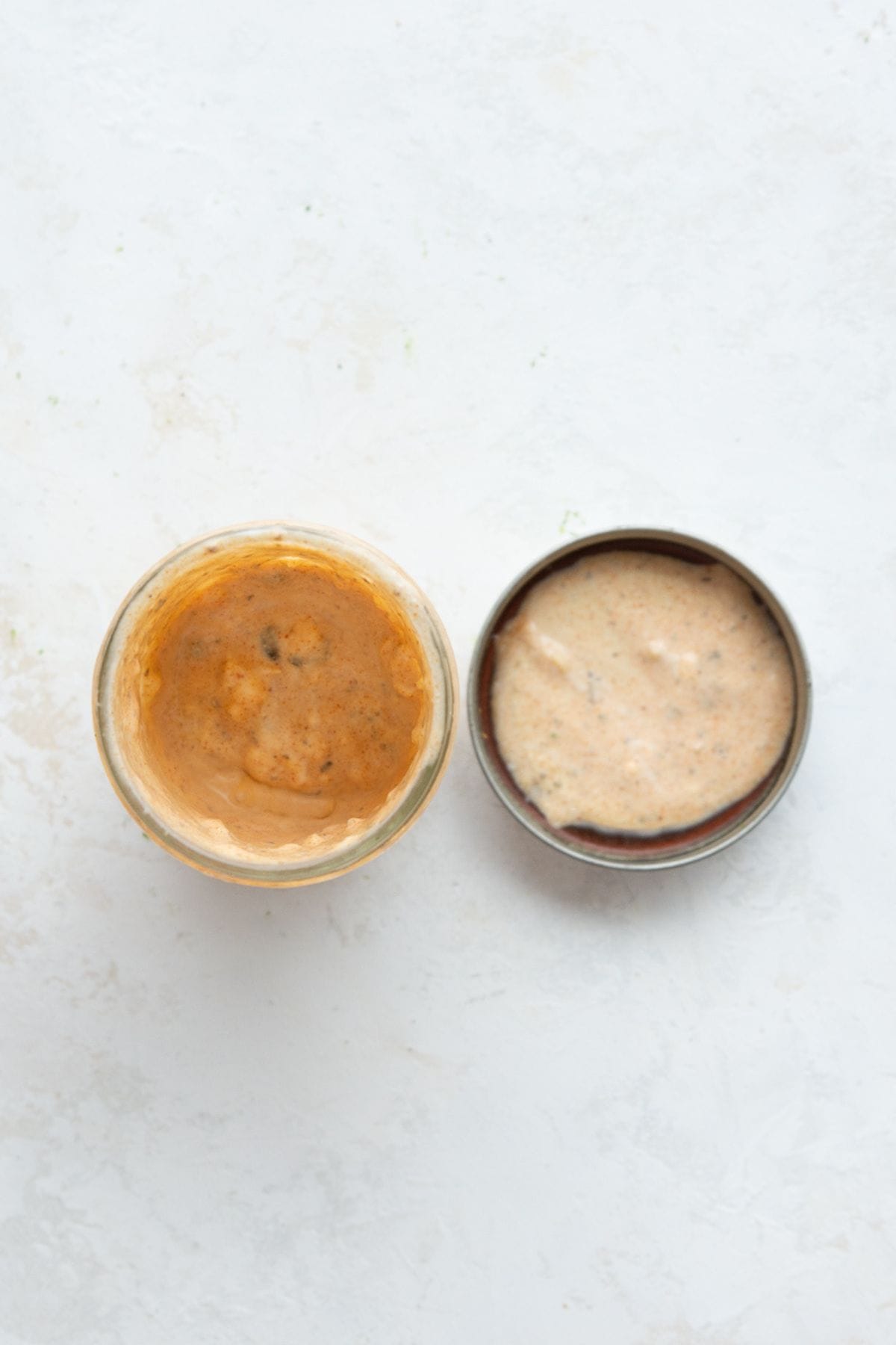 Lemon yogurt dressing in a glass jar next to its lid.