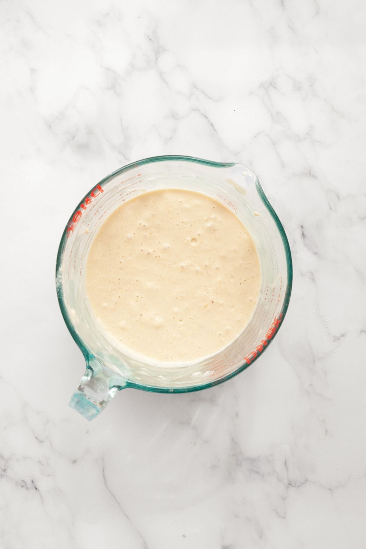 Thick, slightly lumpy pancake batter in a glass bowl, mixed until just combined.
