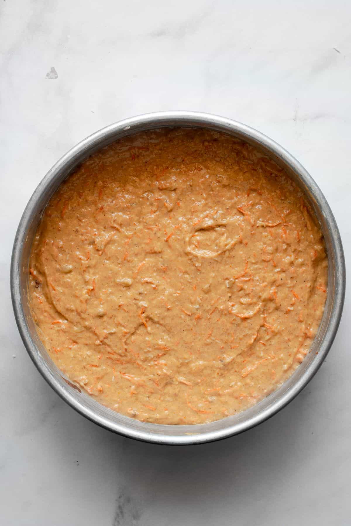 Smoothed pumpkin carrot cake batter in a greased, parchment-lined 6-inch cake pan.