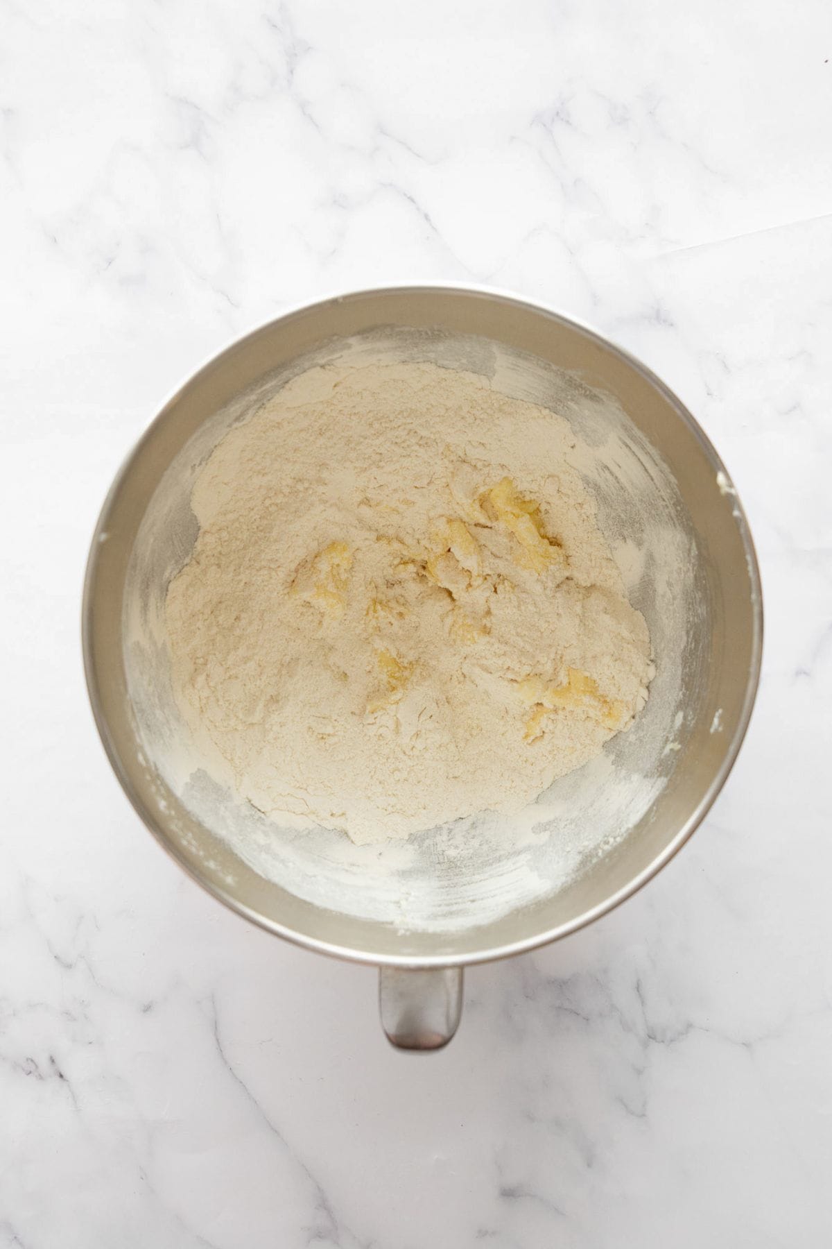 Adding flour, baking soda, and salt to form cookie dough.
