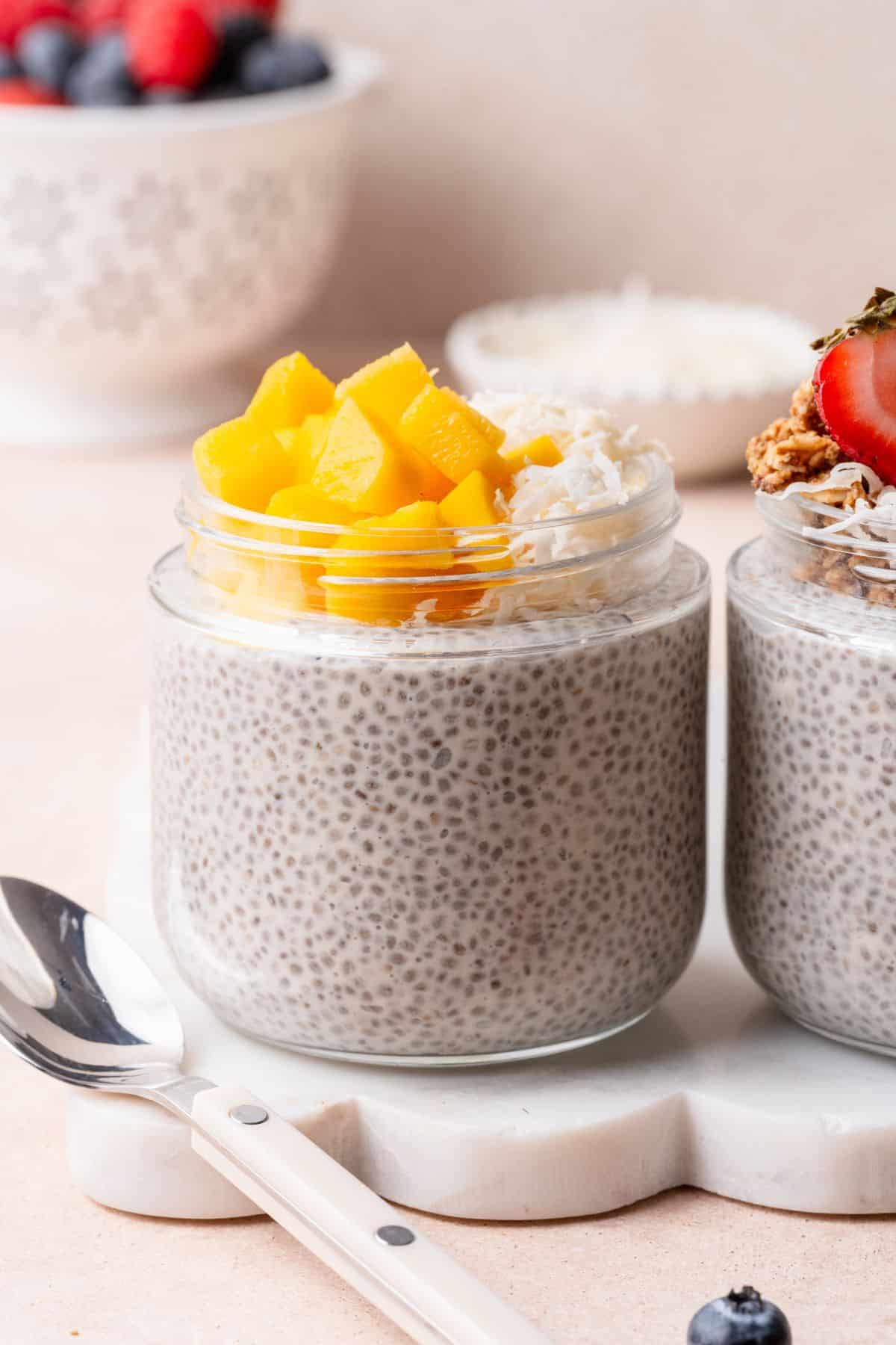 Close-up of thick chia pudding made with coconut milk and topped with fresh mango.