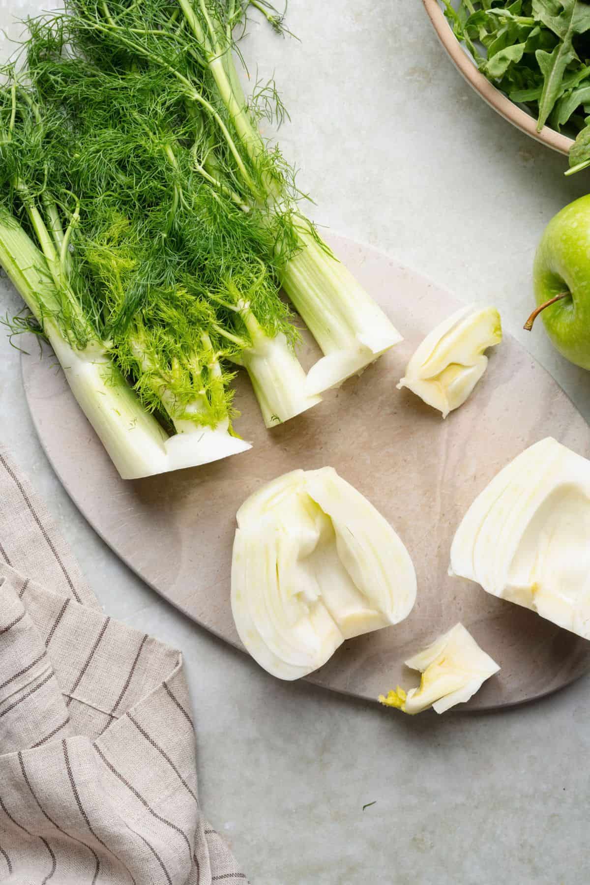 Removing the tough core from fennel bulb halves before shaving.