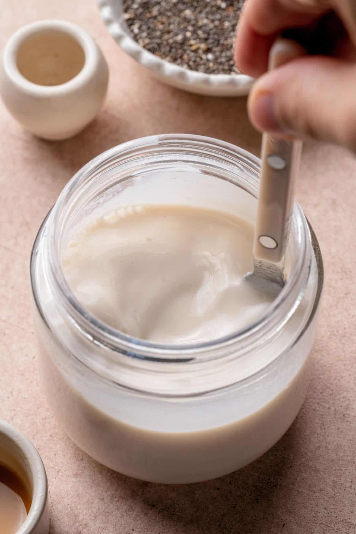 Spoon stirring coconut milk, yogurt, and collagen until smooth.